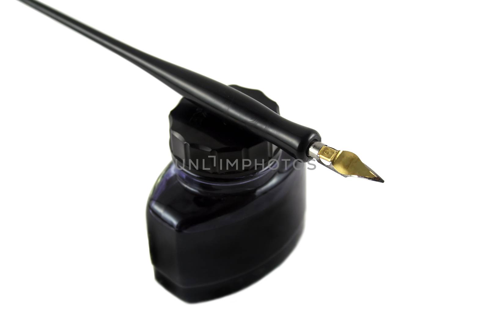Vintage pen lying on top of a bottle of ink.