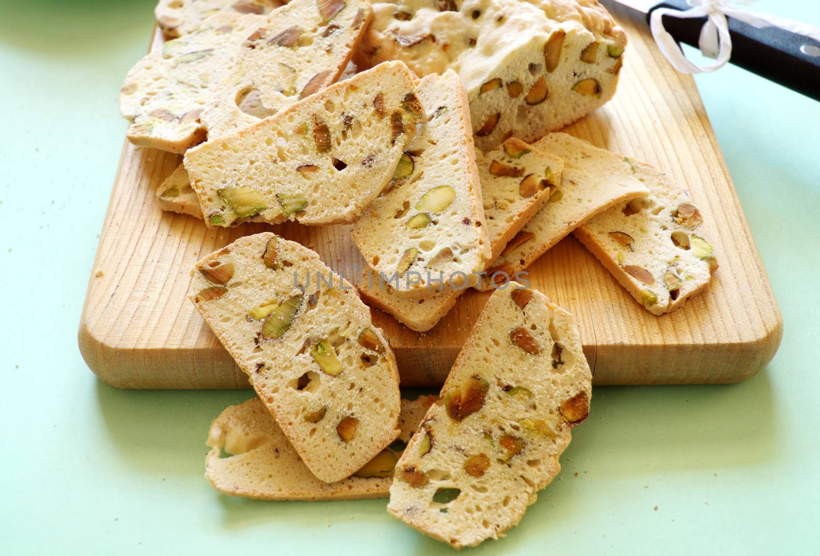 Fresh baked sweet pistachio bread sliced on a bread board ready to serve.
