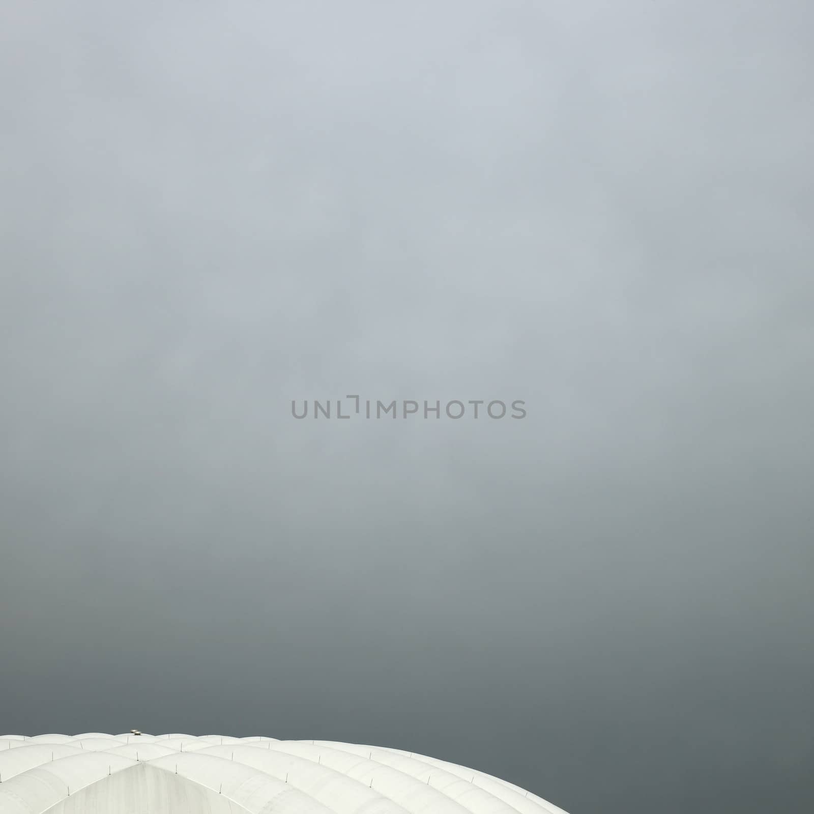 Inflated white roof stadium against cloudy sky