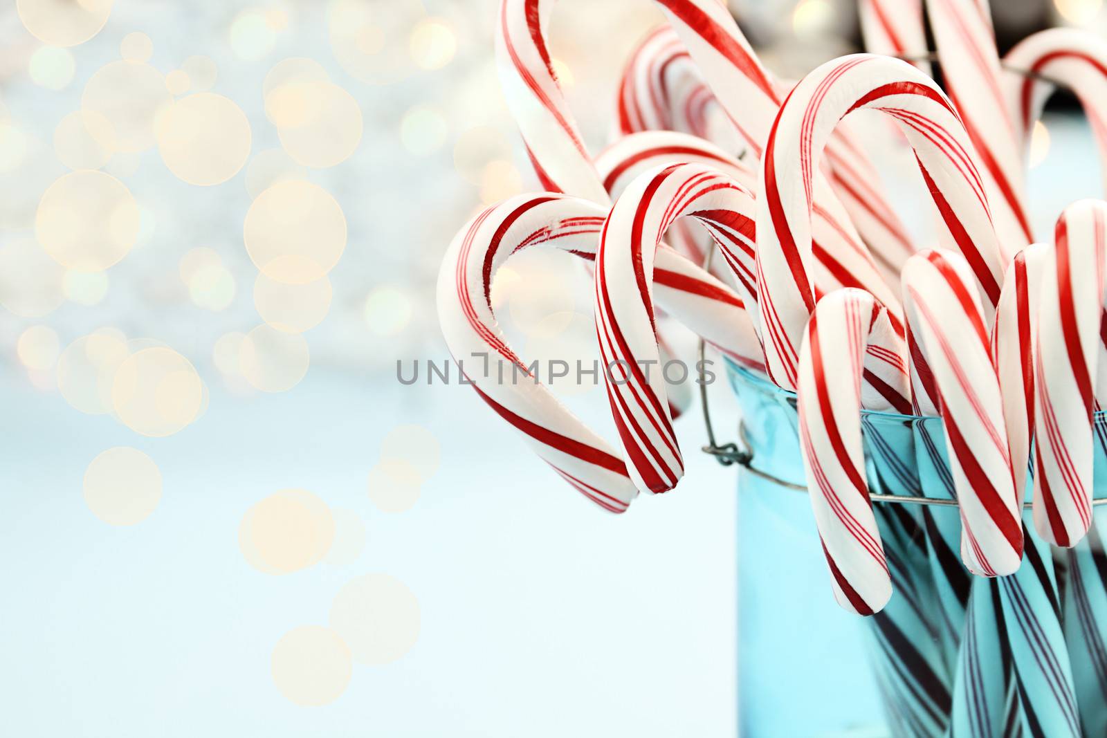 Candy canes in a pretty glass blue Container. Extreme shallow depth of field with selective focus on center candy.