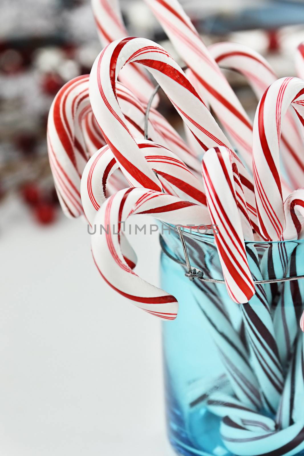 Candy canes in a pretty glass blue Container. Extreme shallow depth of field with selective focus on center candy.