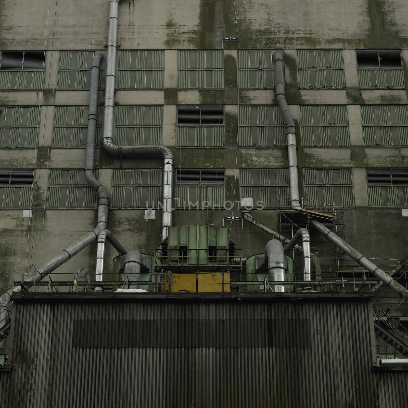 Large dark factory against grey sky