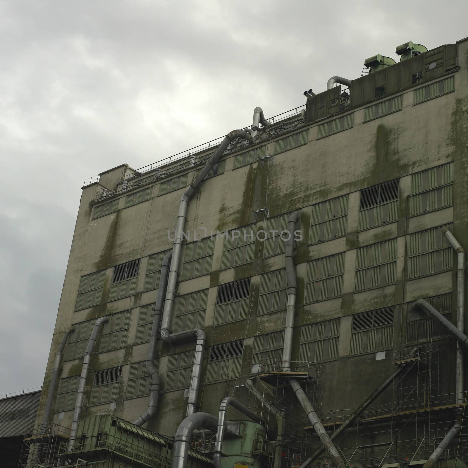 Large dark factory against grey sky