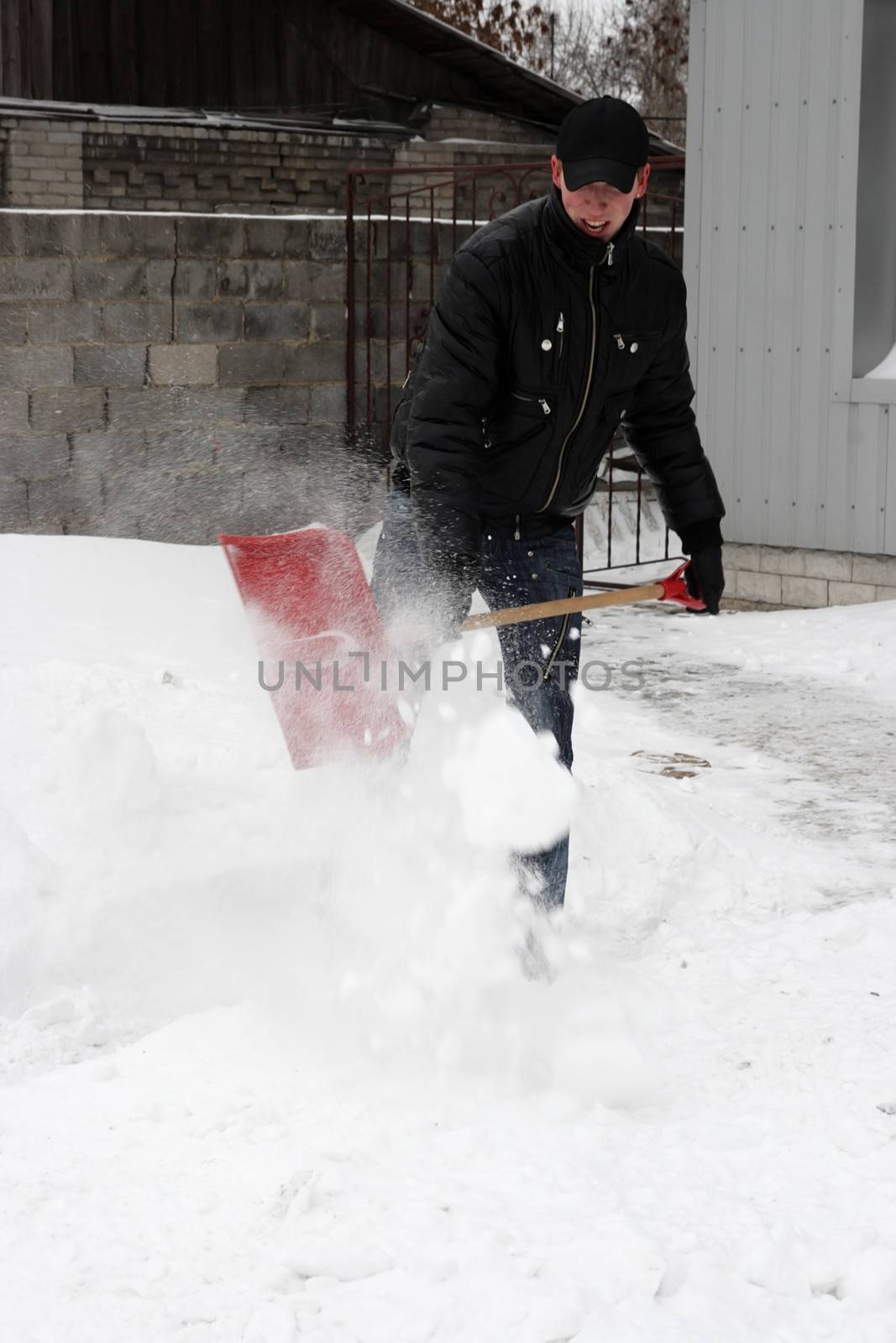 man shoveling snow in a snow storm 