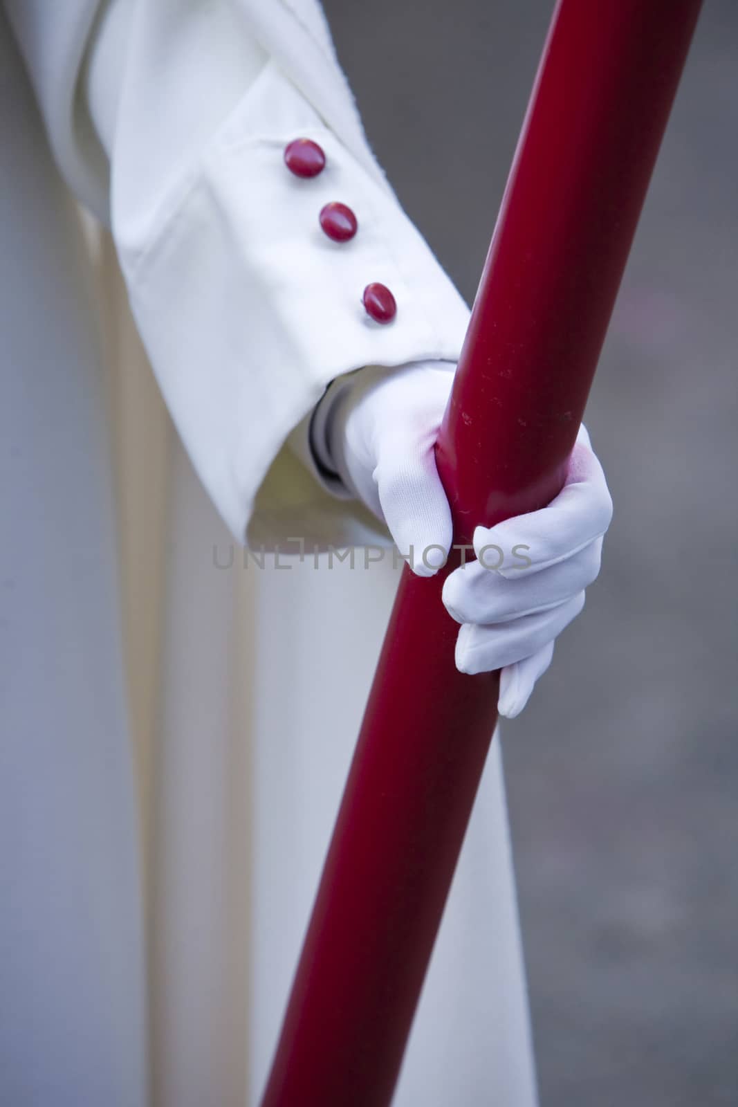 Detail penitent red holding a candle during Holy Week, Spain