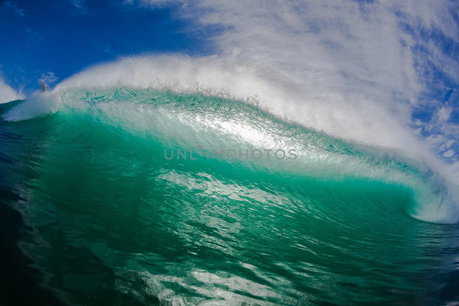 Hollow ocean wave crashing pitching forwards towards swimmers water position angle.