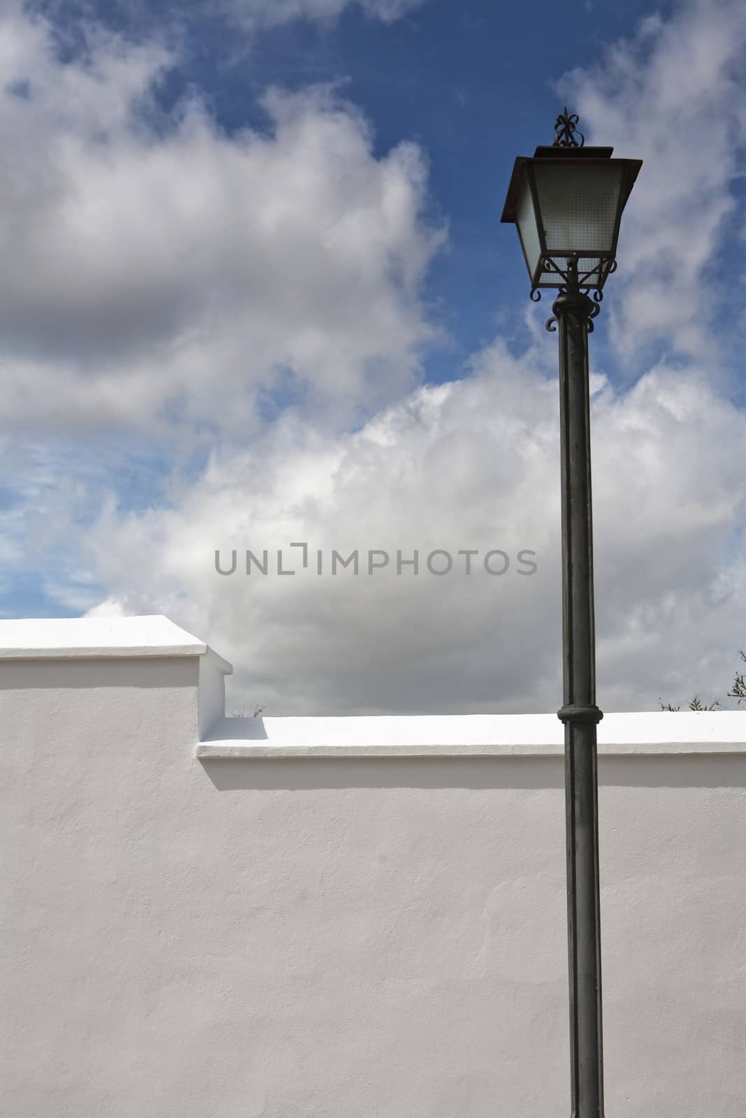 A wrought iron lamp on a weathered wall in Spain