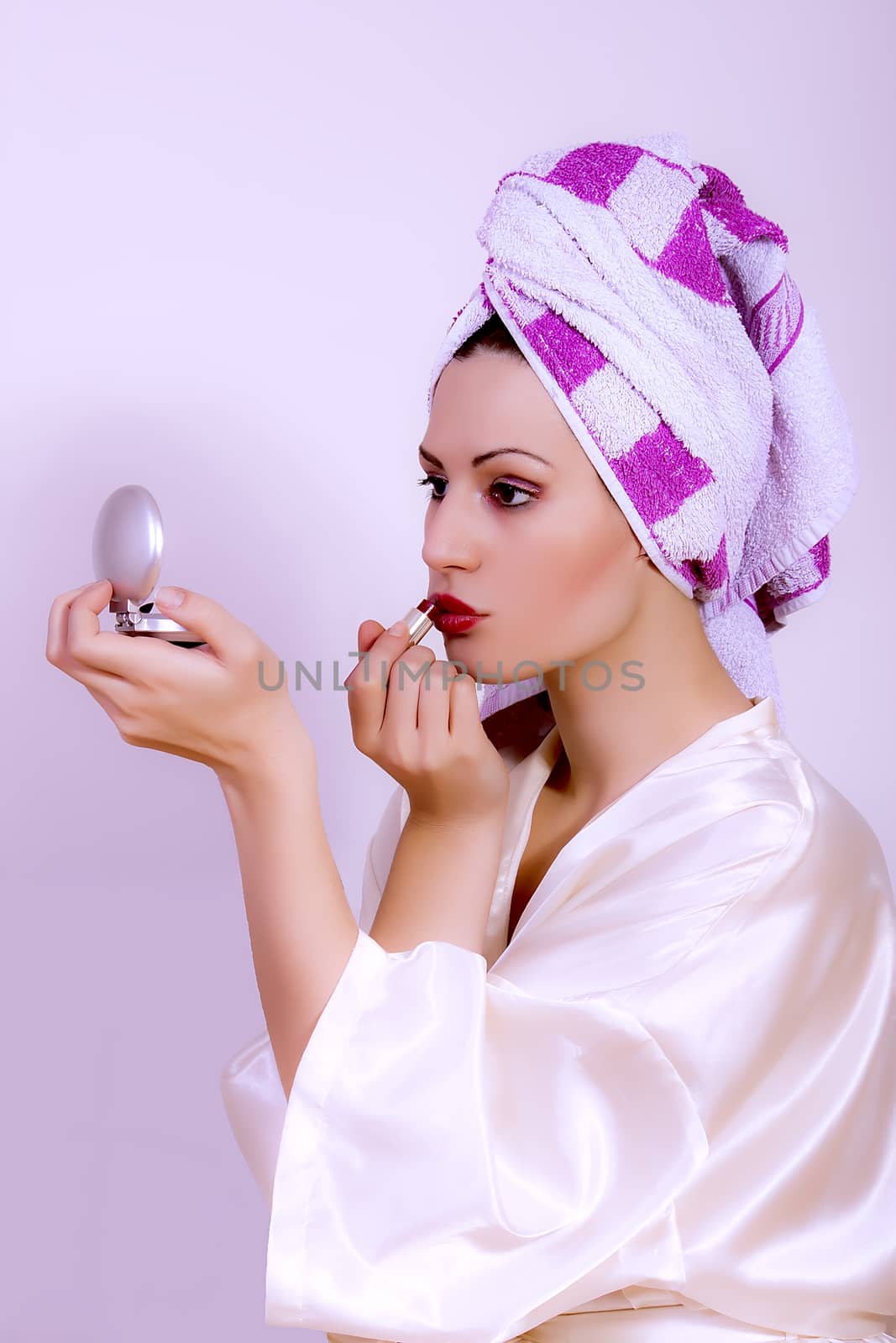 Woman applying make up by dukibu