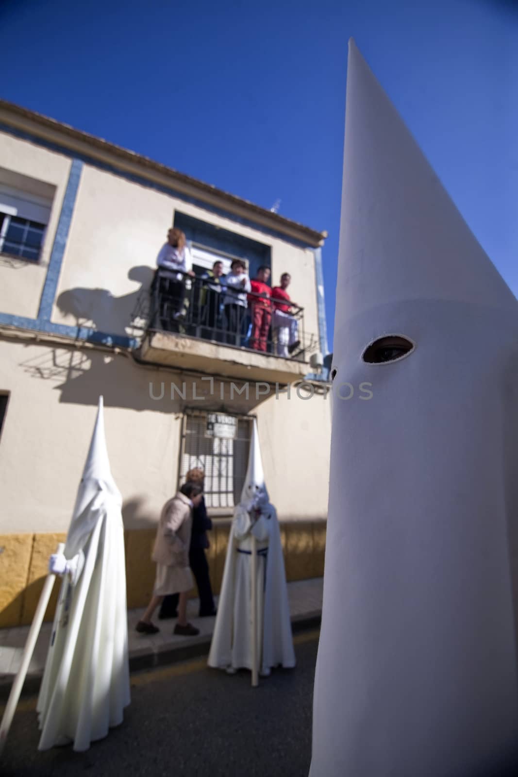 Detail penitent white holding a candle during Holy Week, Spain