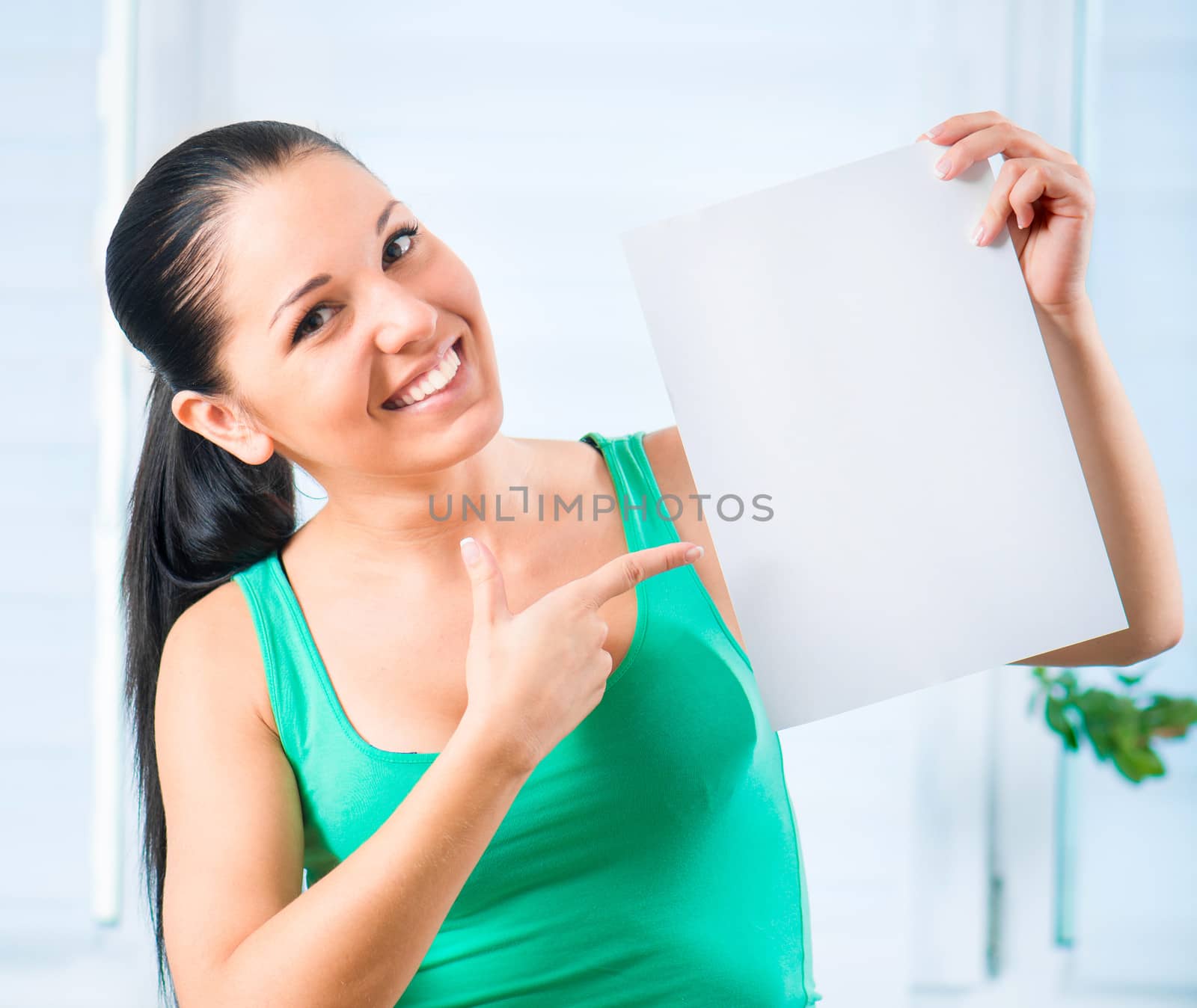 Portrait of happy young casual woman holding a blank signboard, vertically
