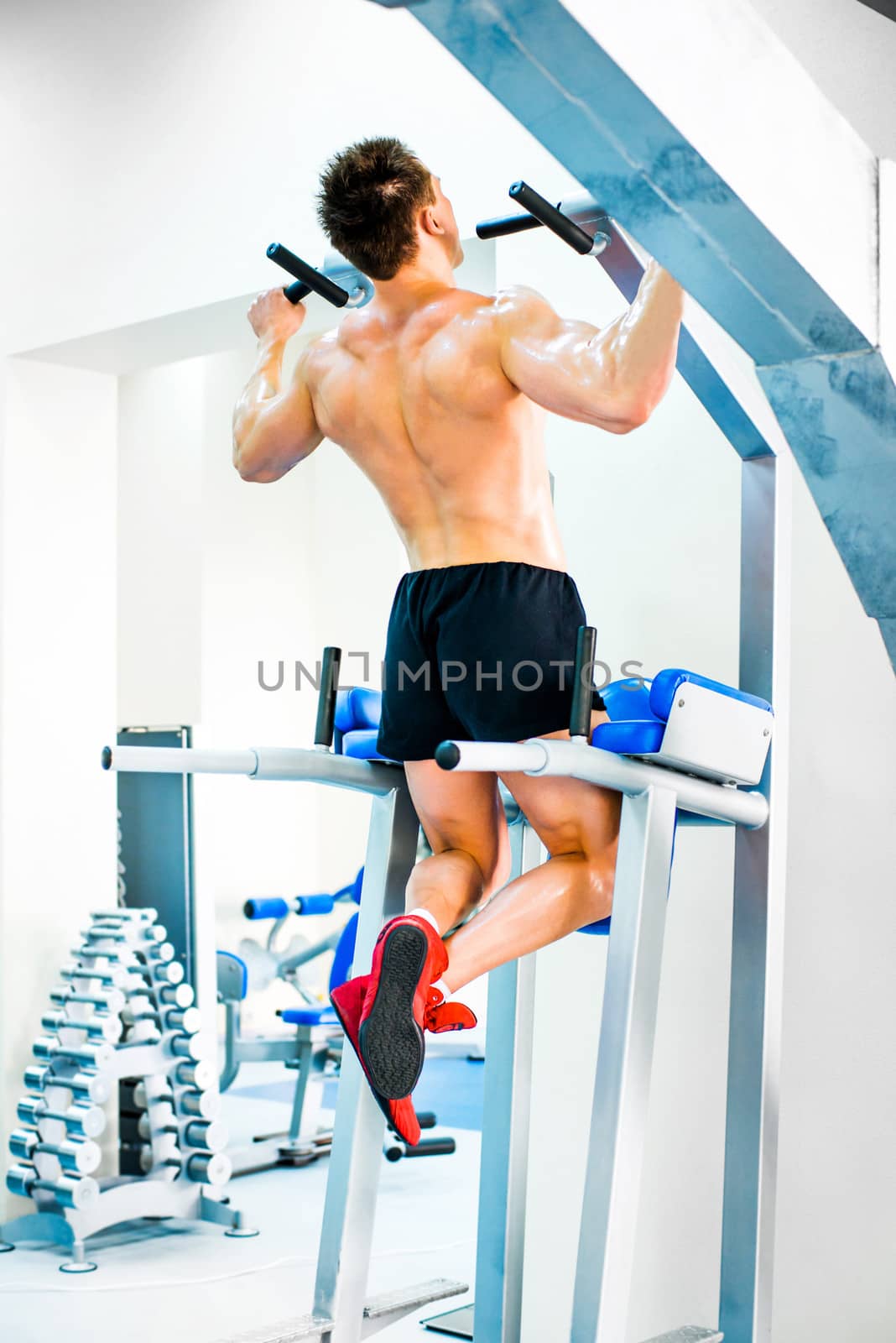 bodybuilder doing exercises on the horizontal bar