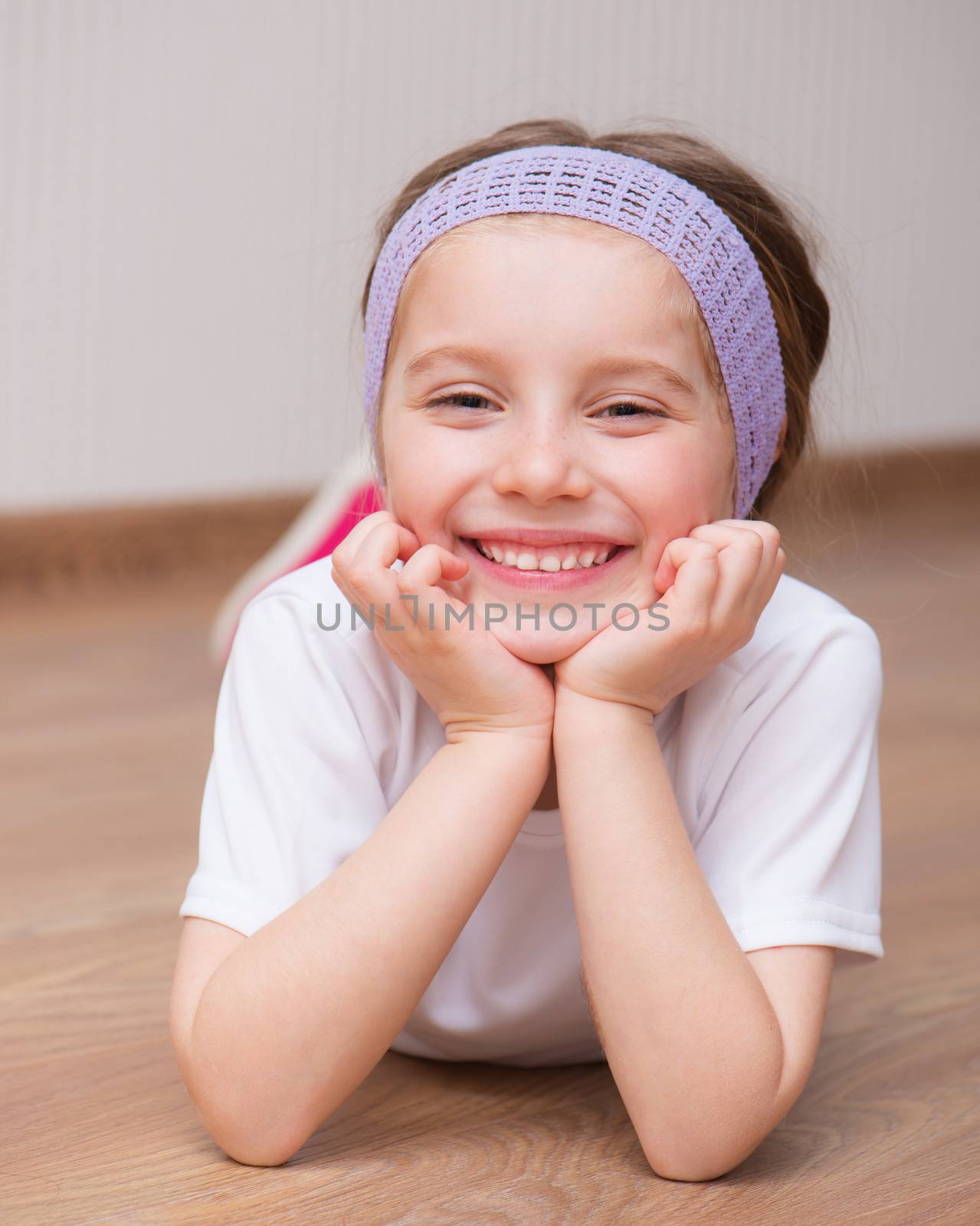 Pretty smiling girl lying on the floor at home