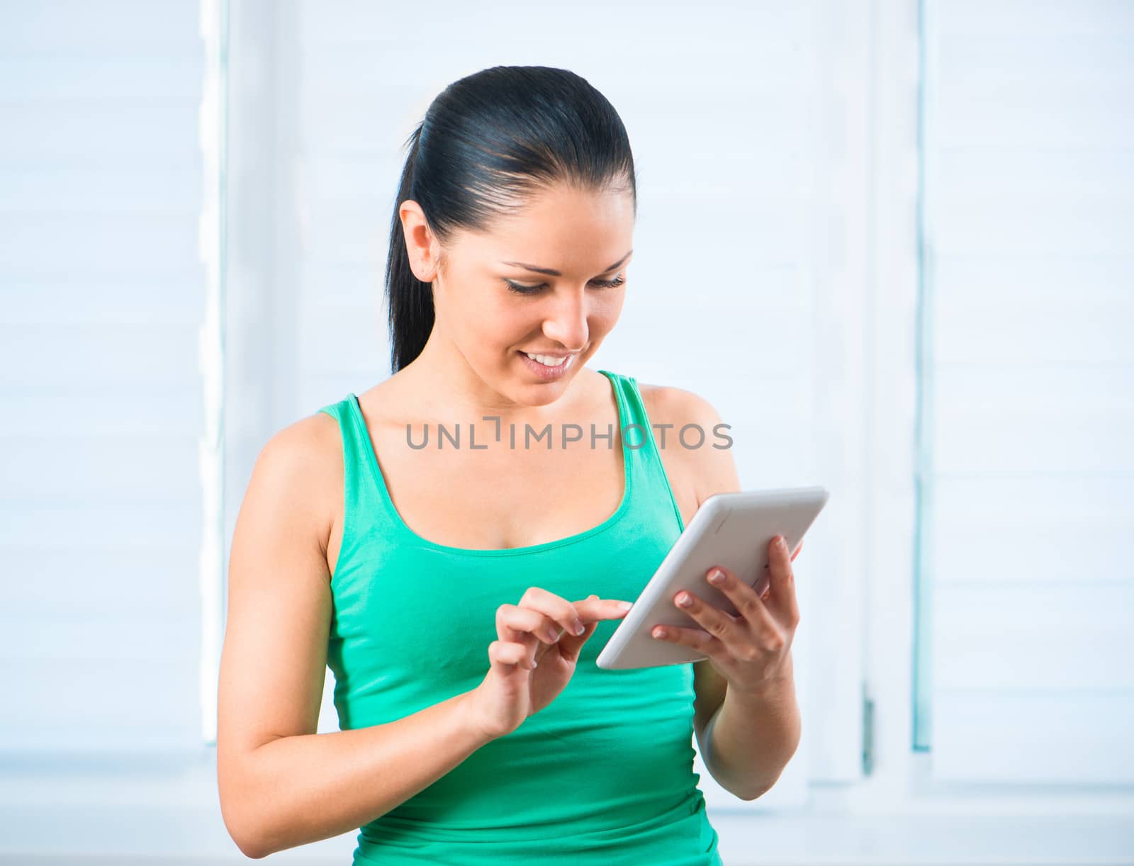 smiling young brunette woman with a white touch tablet