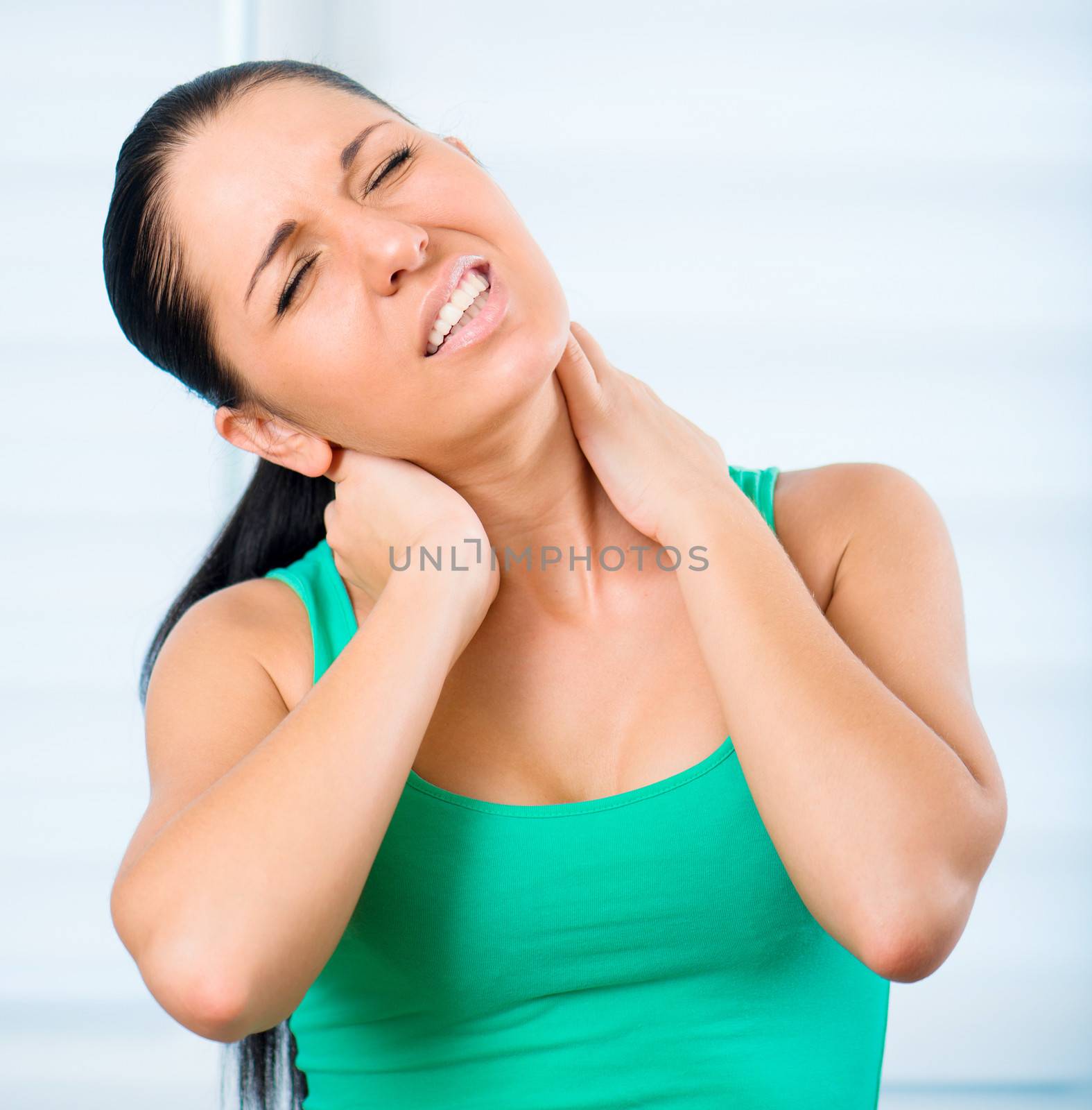 young brunette woman with a pain in the neck