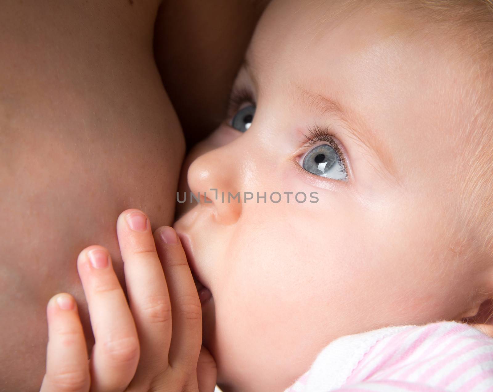 little baby sucking breast mother with open eyes