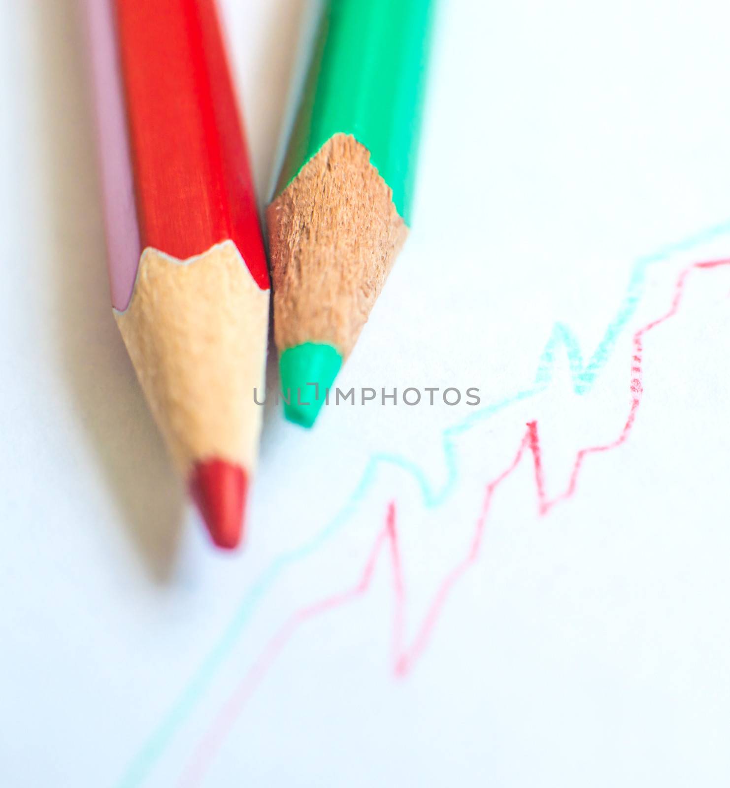 red and green pencil with graph on white paper