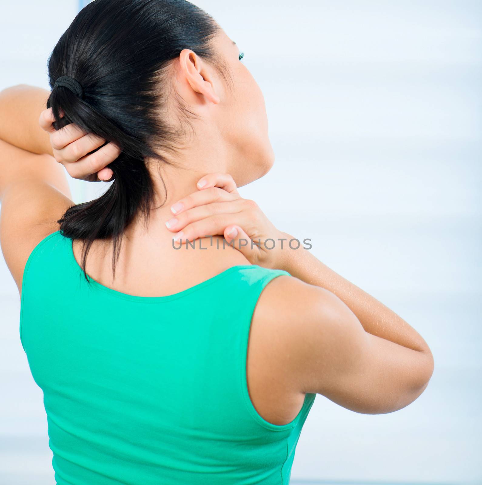 young brunette woman with a pain in the neck
