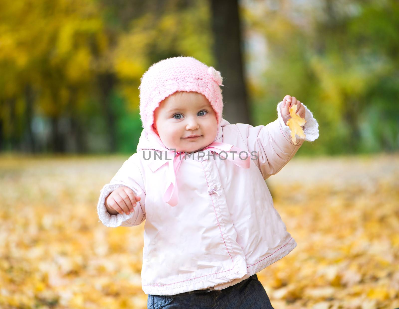 cutelittle baby in the park with autumn leaves