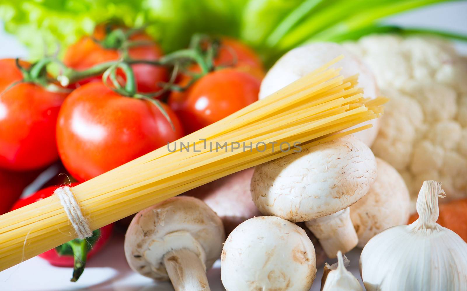 Raw spaghetti with vegetables close up