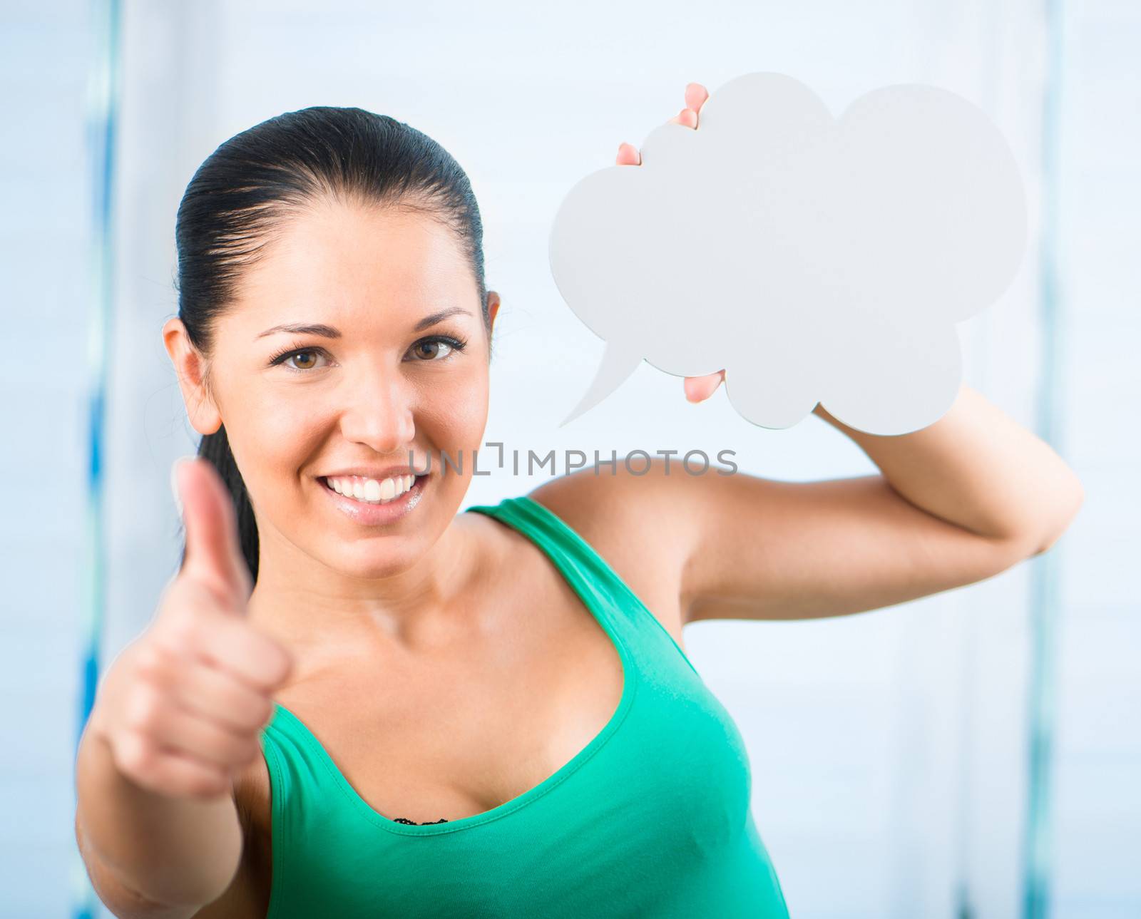young smiling brunette woman holding a white cloud for text with thumb up