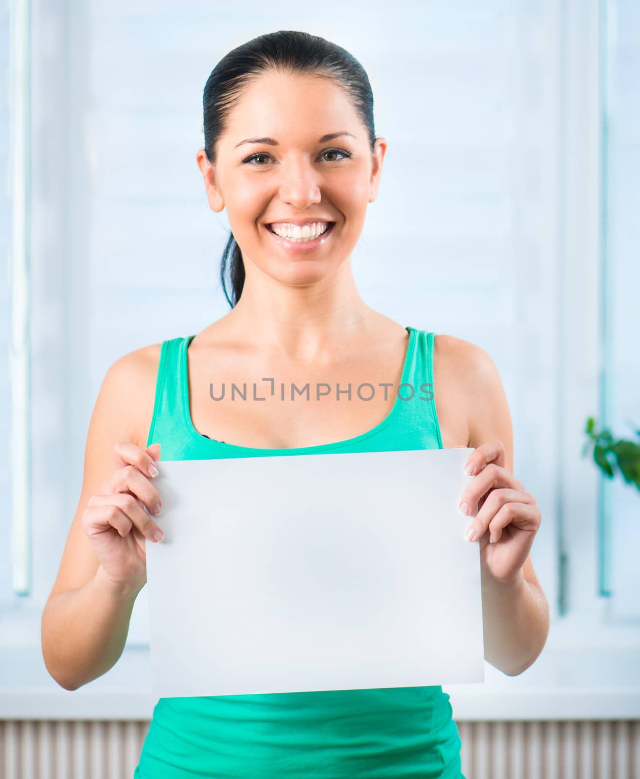 Portrait of happy young casual woman holding a blank signboard, horizontally