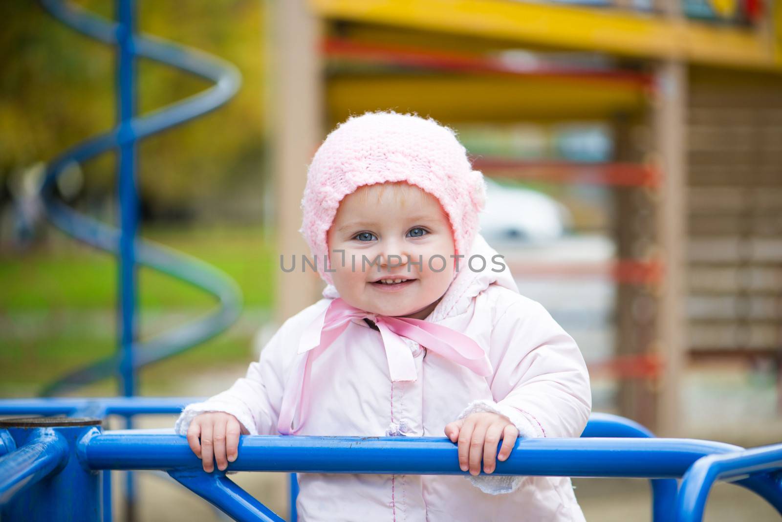smiling little baby in a swing at the park