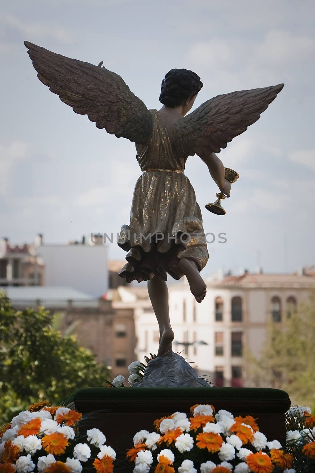 Figure of an angel with wings sculpted in wood with the sacramental cup. Holy week, Spain
