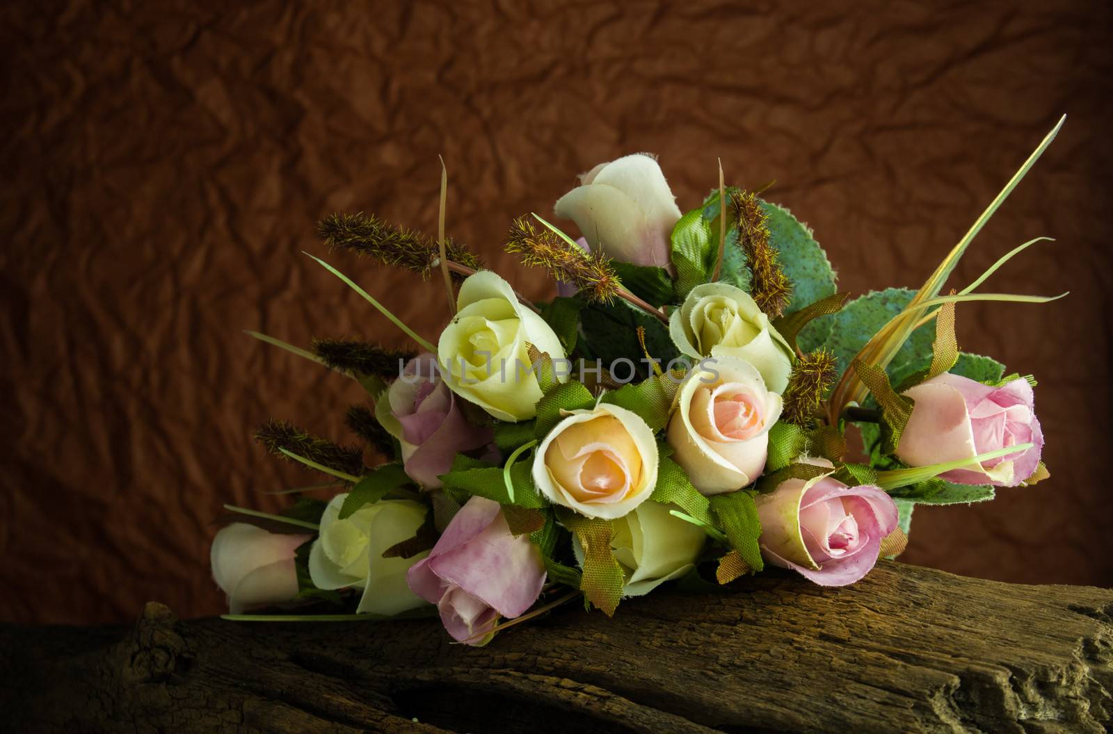 fake roses on timber with dark background