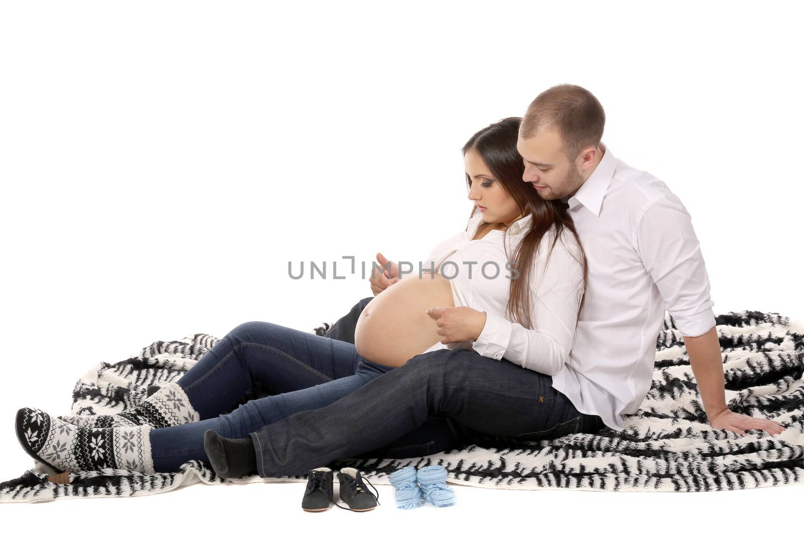 Beautiful couple expecting a baby on the blanket