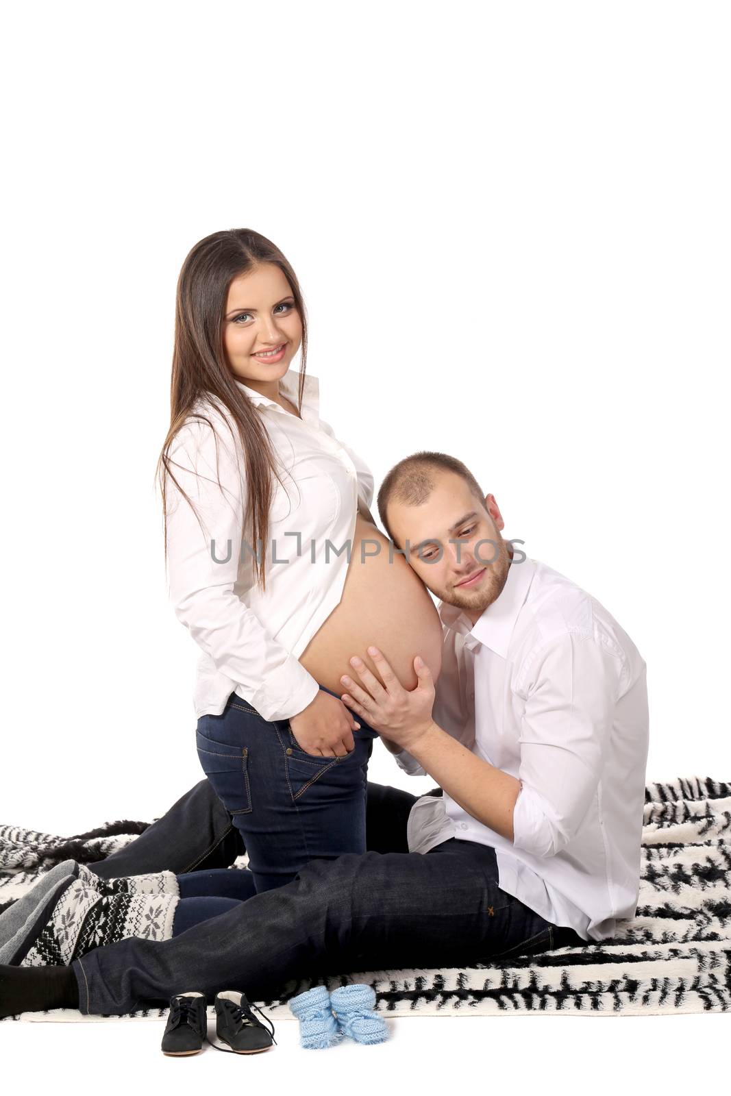 Happy men listen belly of pregnant woman. by indigolotos