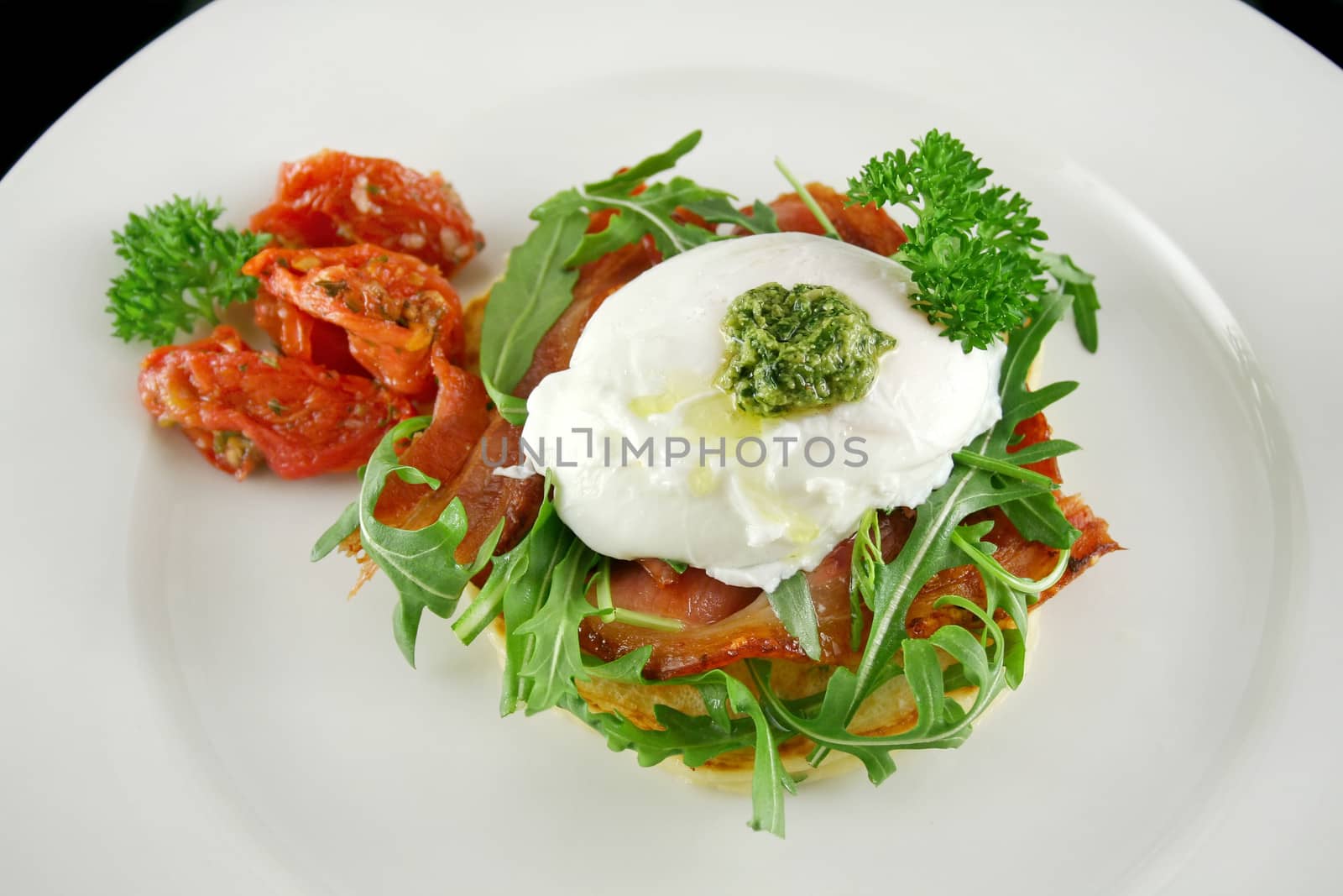 Poached egg with pesto, bacon, greens and sun dried tomatoes.
