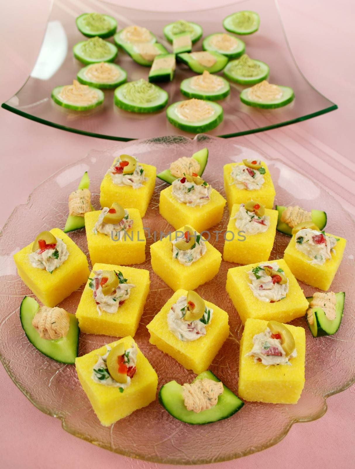 Finger food of tuna filled polentas and cucumber rounds ready to serve.