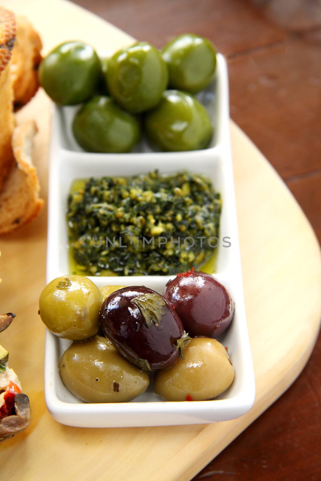 Delicious serving of rustic red and green olives with pesto.