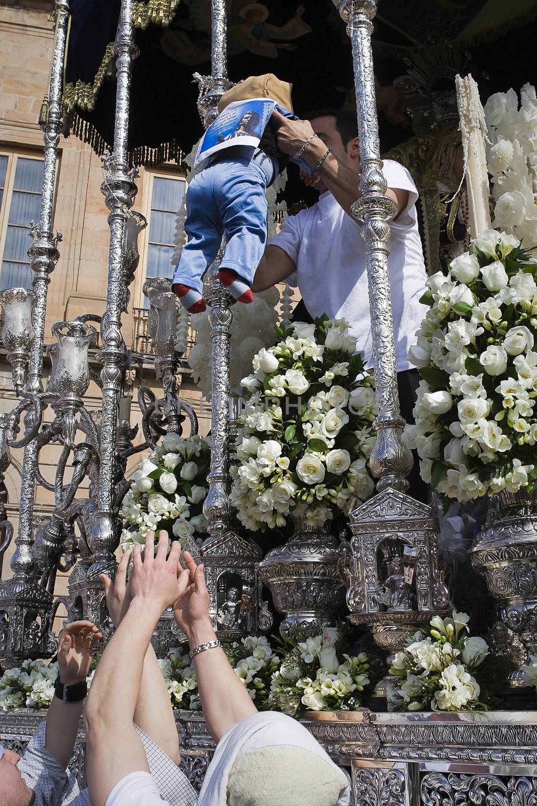 Popular Custom to bless a baby before the Virgin in a throne during Holy Week, Andalucia, Spain