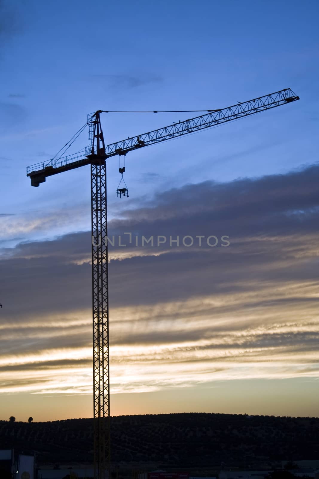 crane abandoned at the sunset in a construction of buildings, Spain