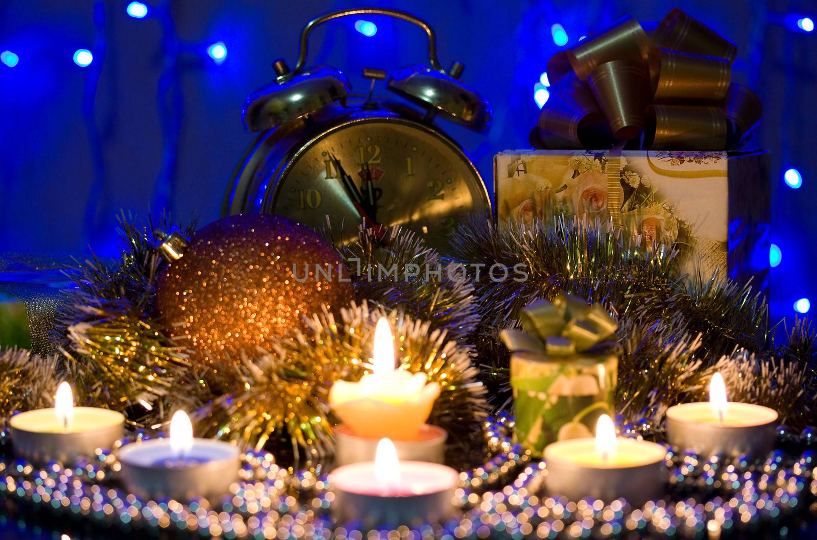 Candle on the background of the Christmas tree and gifts