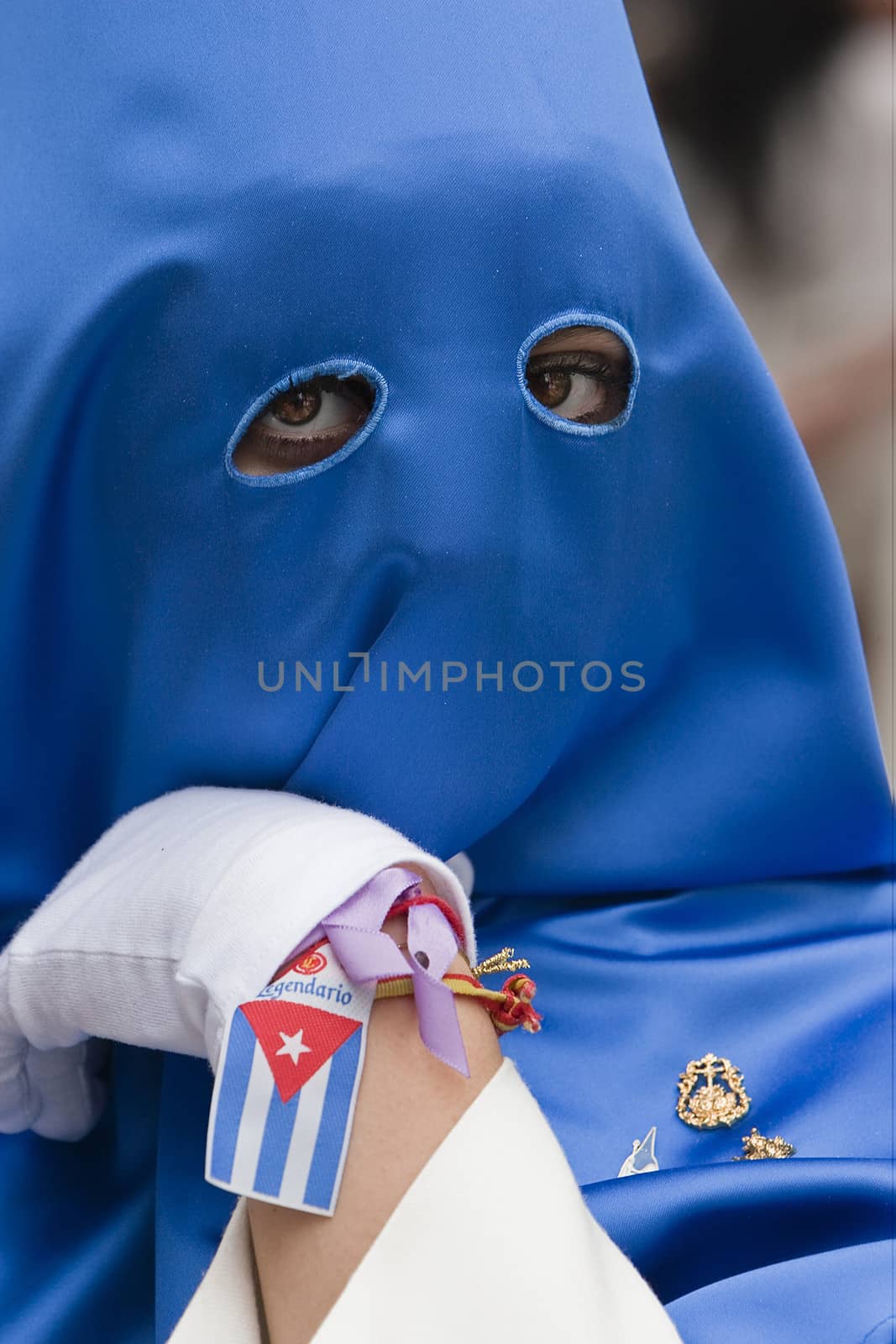 Penitent with caperuz blue of penetrating look and nice eyes during a procession of Holy Week, Andalusia, Spain