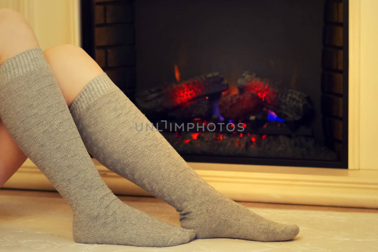 Female feet in socks on a background of fire