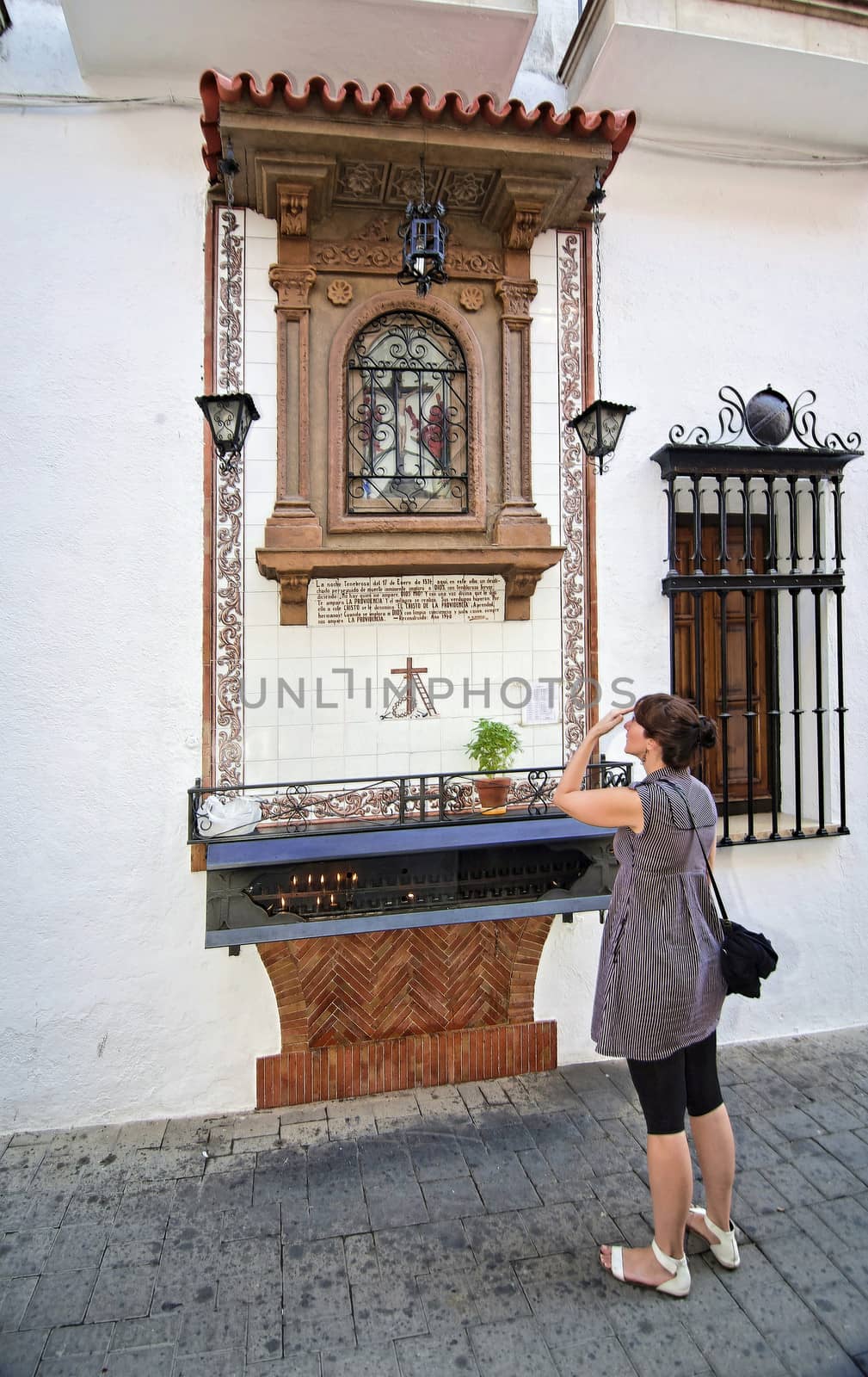 Woman praying before the altar of the Christ of Providence, Andujar, Jaen province, Andalusia, Spain