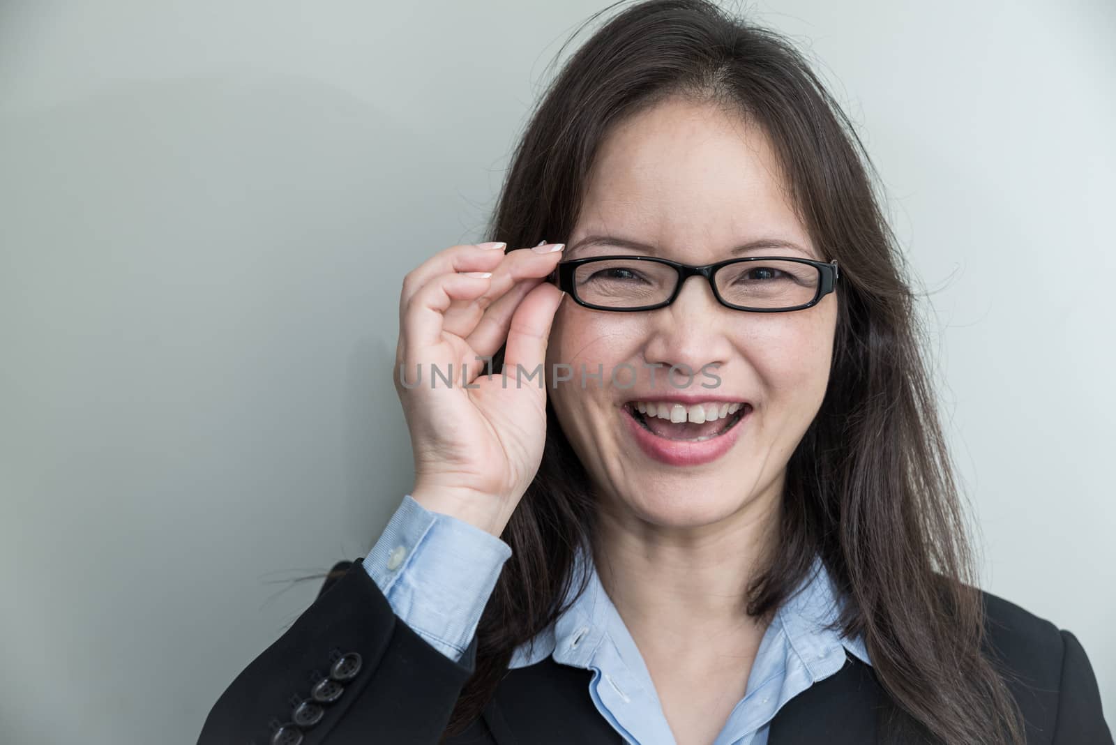 Woman with glasses smiling by IVYPHOTOS