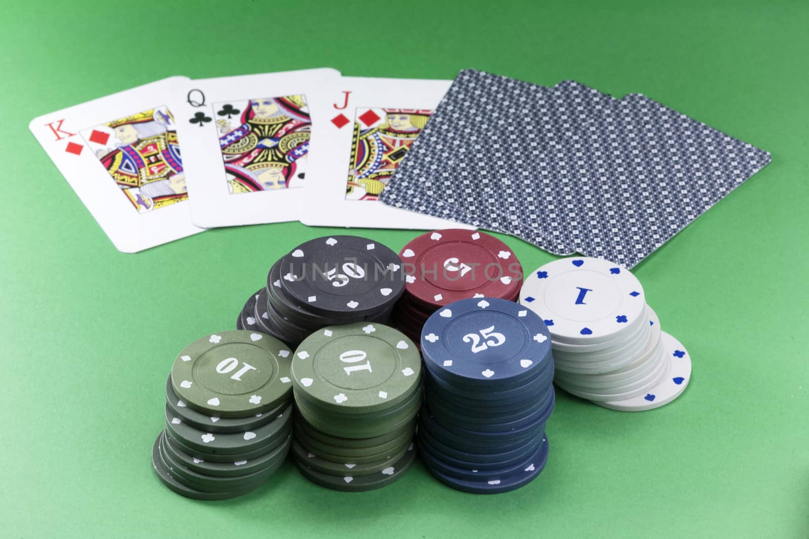 Poker chips and cards on felt on green