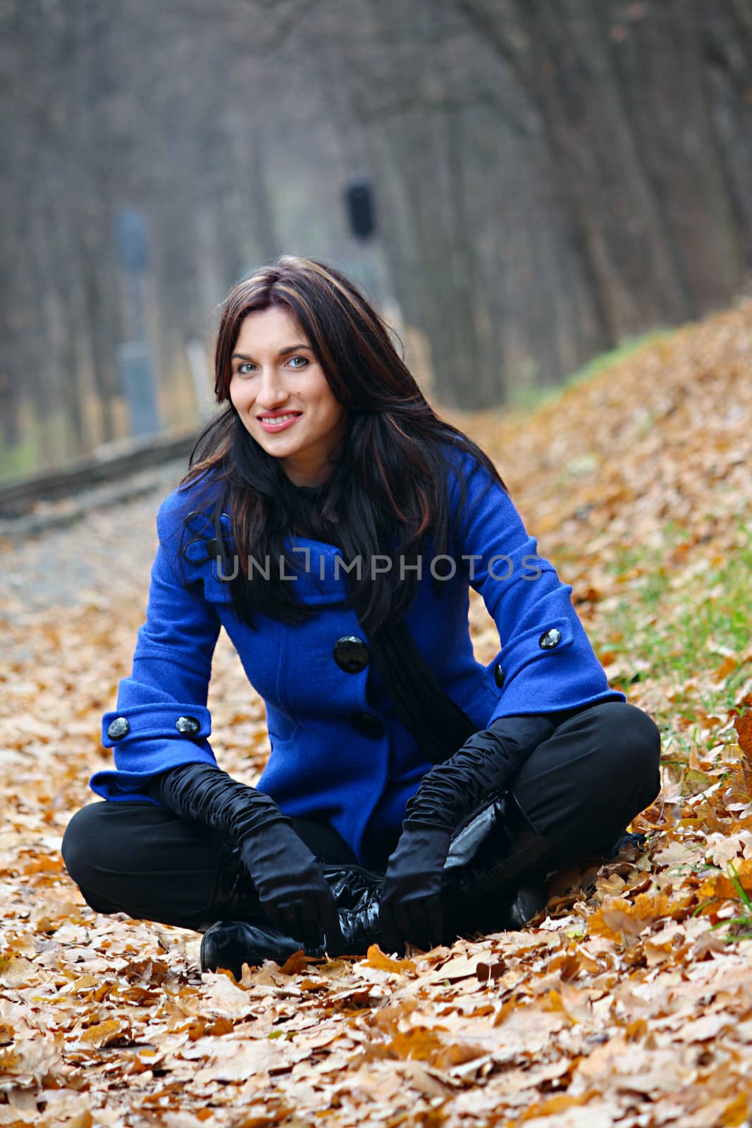 Young woman sitting in the autumn park