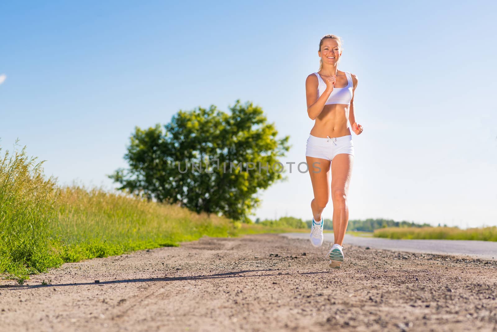 young athletic woman running on the road, exercise outdoors