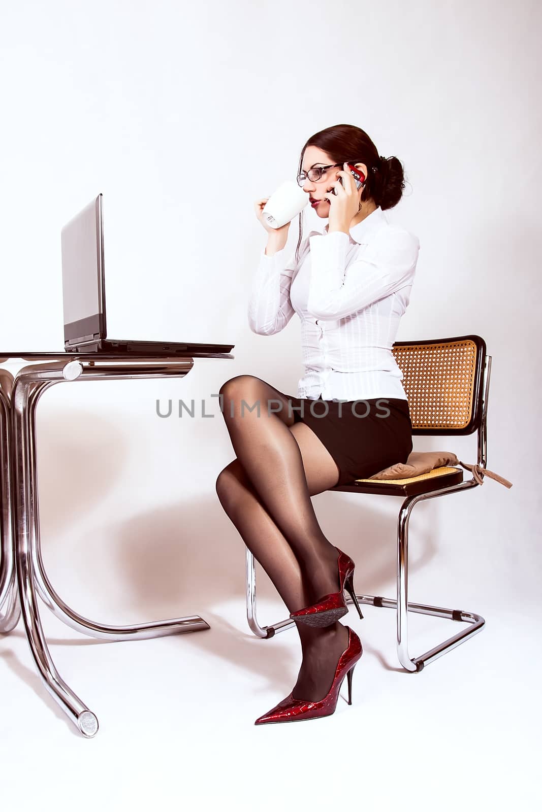 Businesswoman sitting at desk working on a computer by dukibu