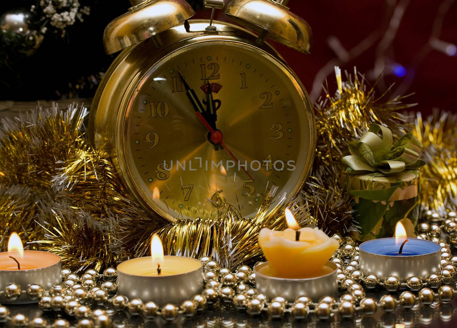 Christmas gift on a background of candles and hours