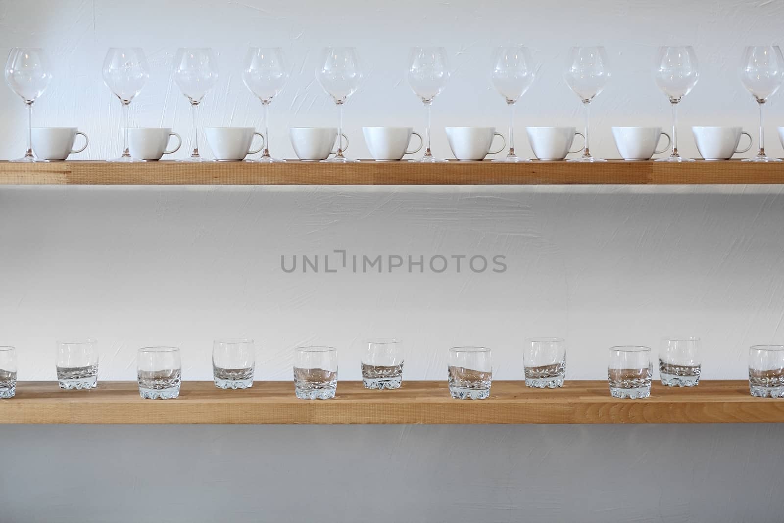 Some cups and glasses on a shelf at wall