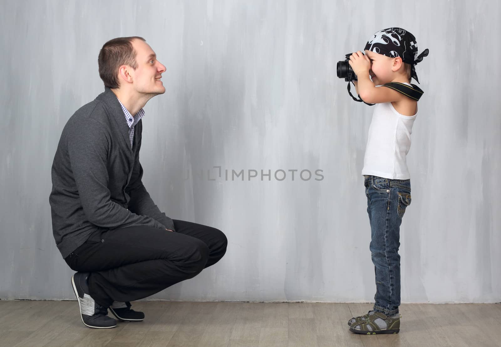 Little boy takes a photo of a man by dedmorozz