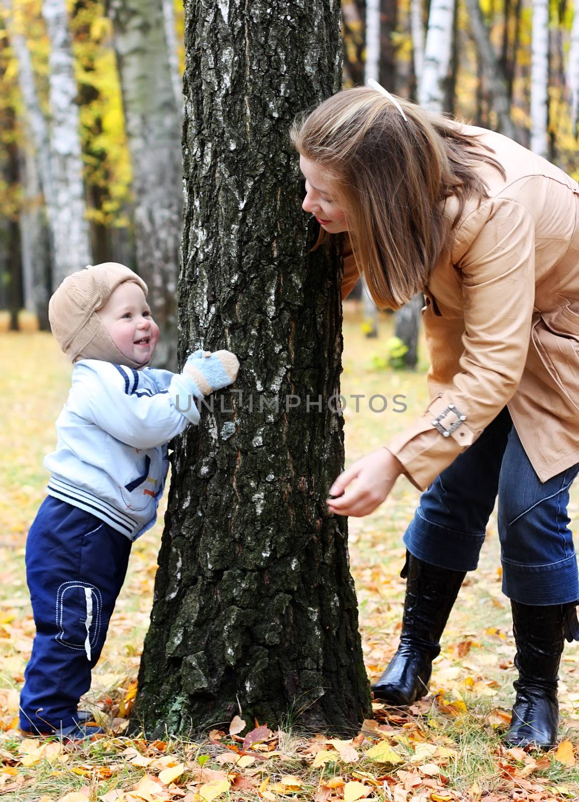 Mother and son play hide-and-seek in a park