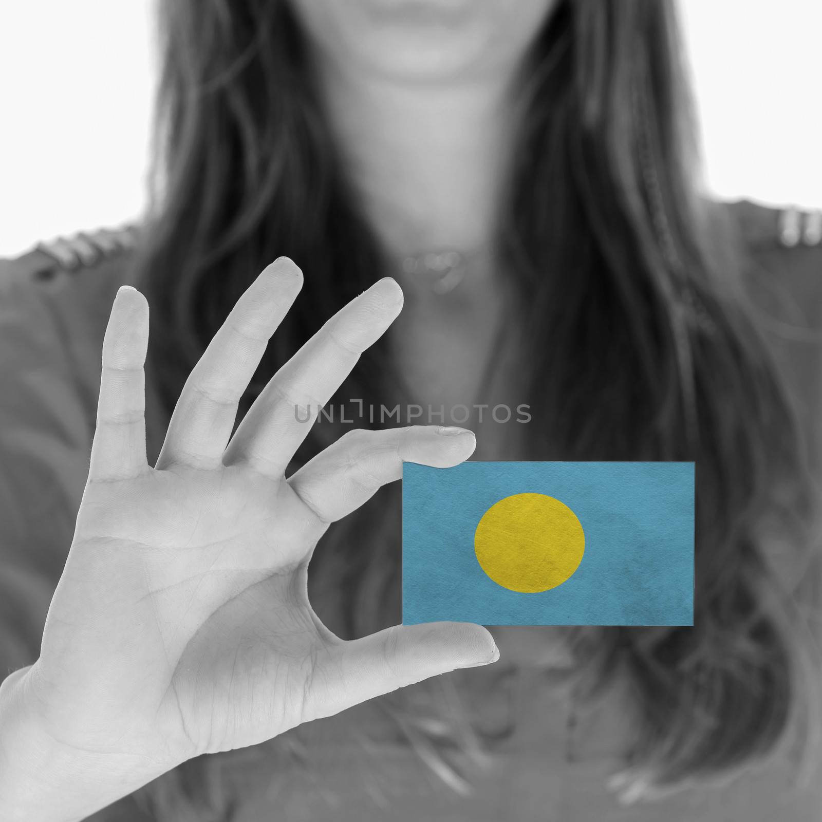 Woman showing a business card, flag of Palau