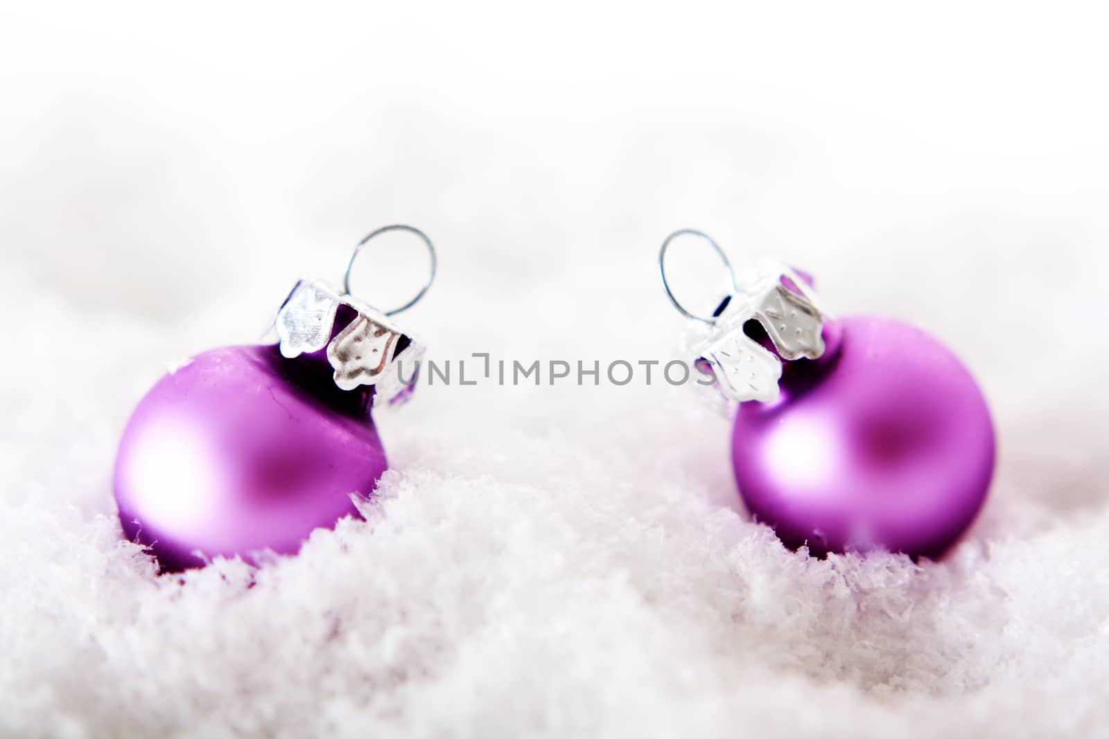 pink christmas balls on snow with white background 